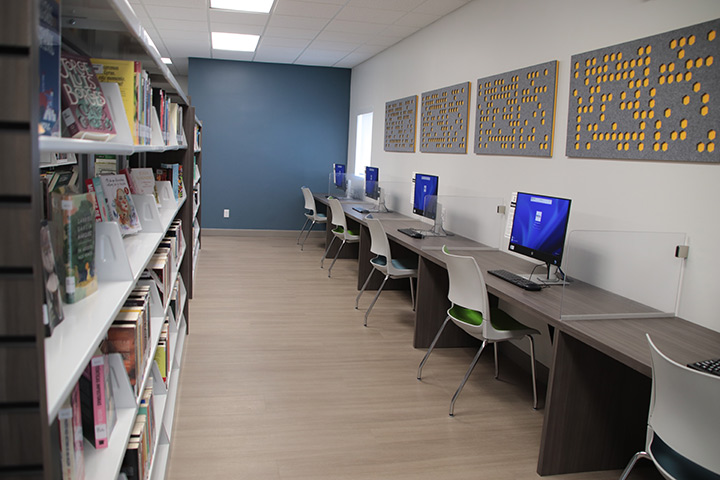 Room of books opposite row of computers