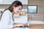 Woman using laptop in kitchen